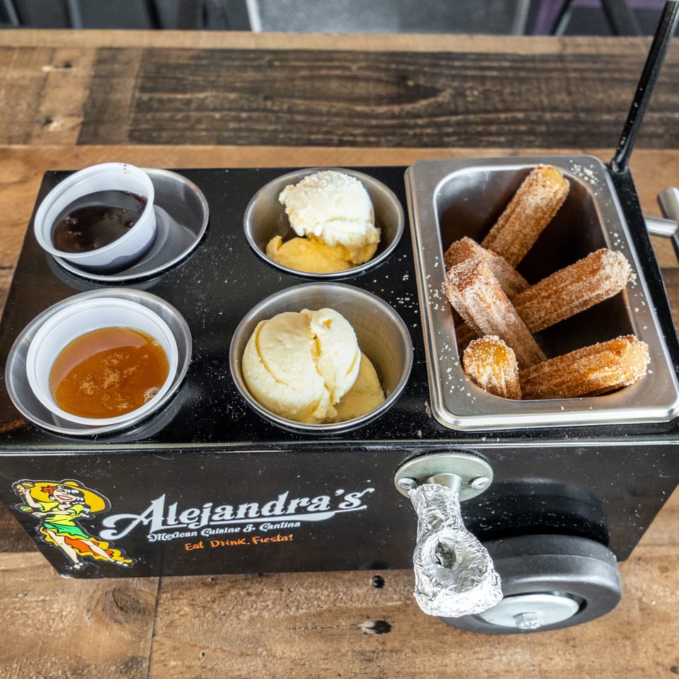 Alejandra’s Mexican cuisine cart serving cinnamon-sugar churros with vanilla ice cream and dipping sauces.
